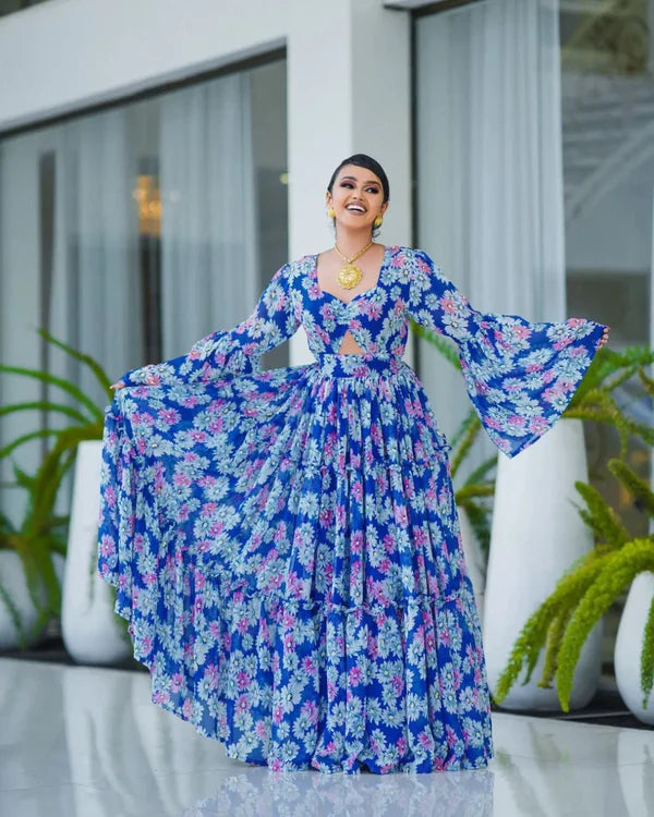 A stunning blue Habesha chiffon dress with a cutout design and pink floral accents.