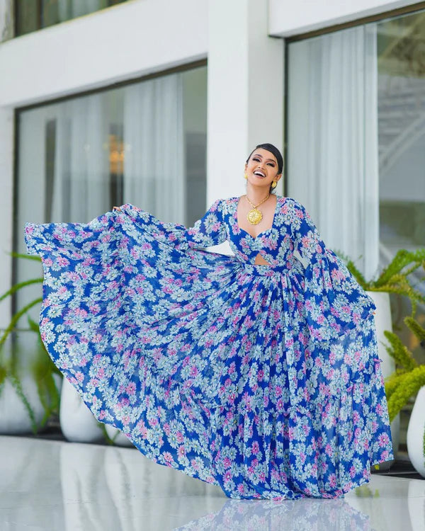 A stunning blue Habesha chiffon dress with a cutout design and pink floral accents.