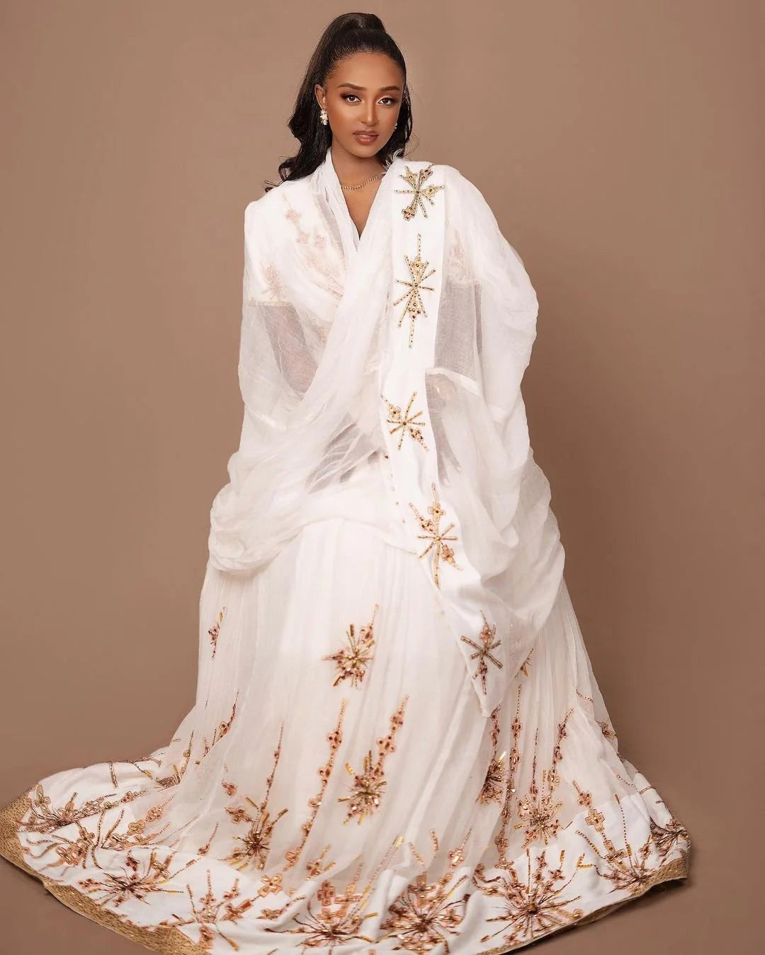 A Habesha Wedding dress in Menen fabric with a Shimena bottom and a white and gold Tilf design