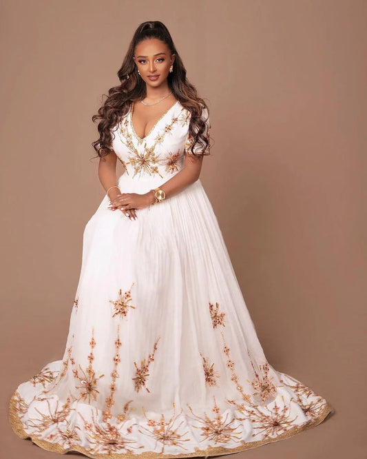 A Habesha Wedding dress in Menen fabric with a Shimena bottom and a white and gold Tilf design