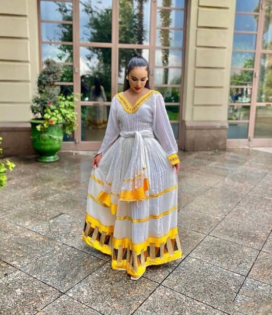 Vibrant yellow Habesha dress, showcasing elegance in traditional attire