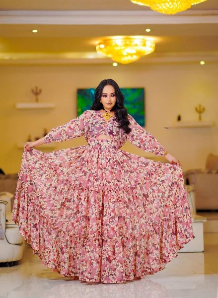 A stylish pink Habesha chiffon dress with cutouts and floral details.