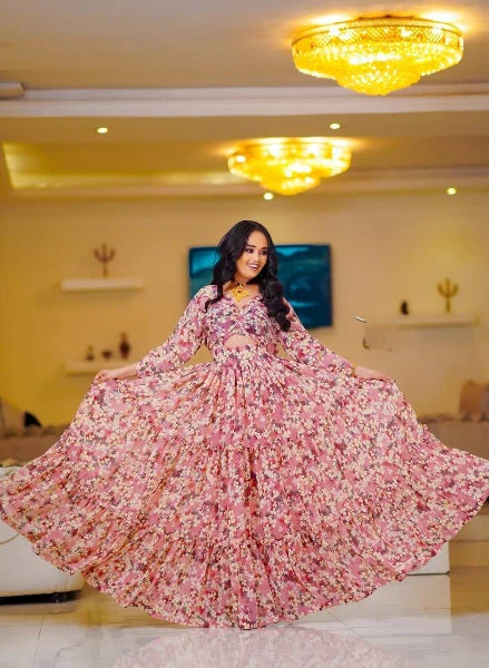 A stylish pink Habesha chiffon dress with cutouts and floral details.