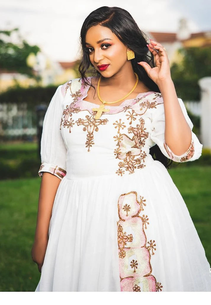 charming Habesha wedding dress exudes elegance with its delicate pink hue and exquisite detailing