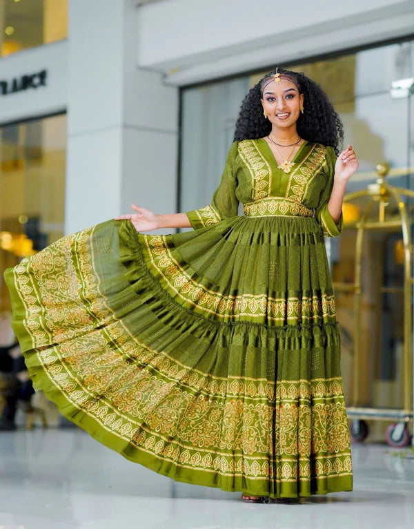 breathtaking light green Habesha chiffon dress, adorned with exquisite golden embellishments, is a truly stunning garment.