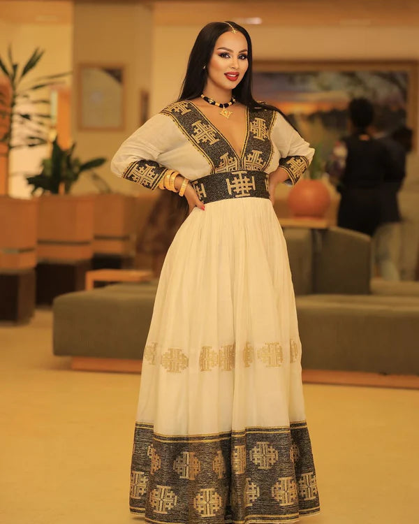 A stunning black and gold Habesha Kemis featuring intricate geometric cross embellishments