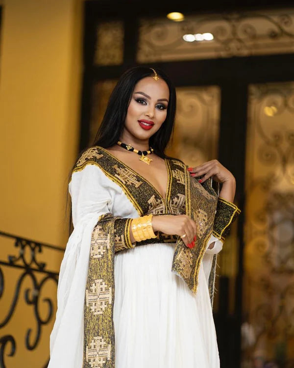 A stunning black and gold Habesha Kemis featuring intricate geometric cross embellishments