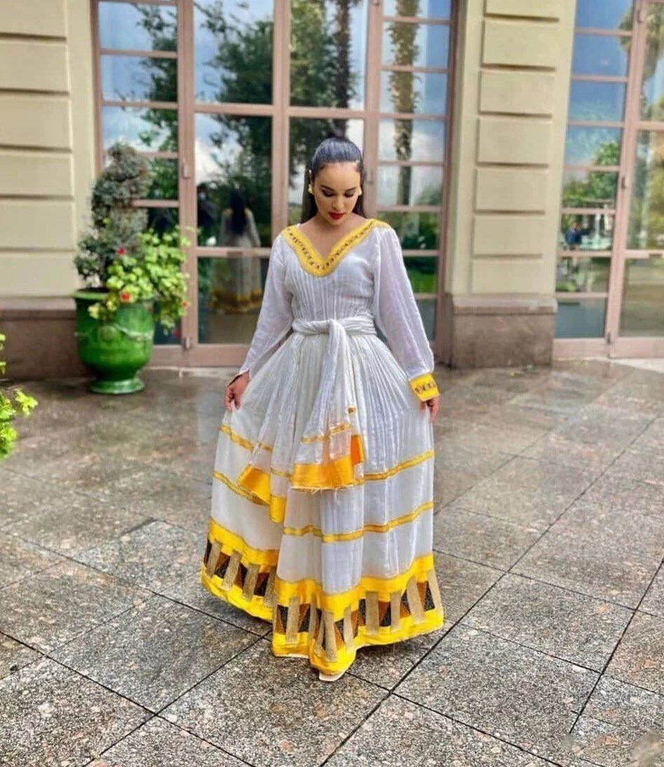 Vibrant yellow Habesha dress, showcasing elegance in traditional attire