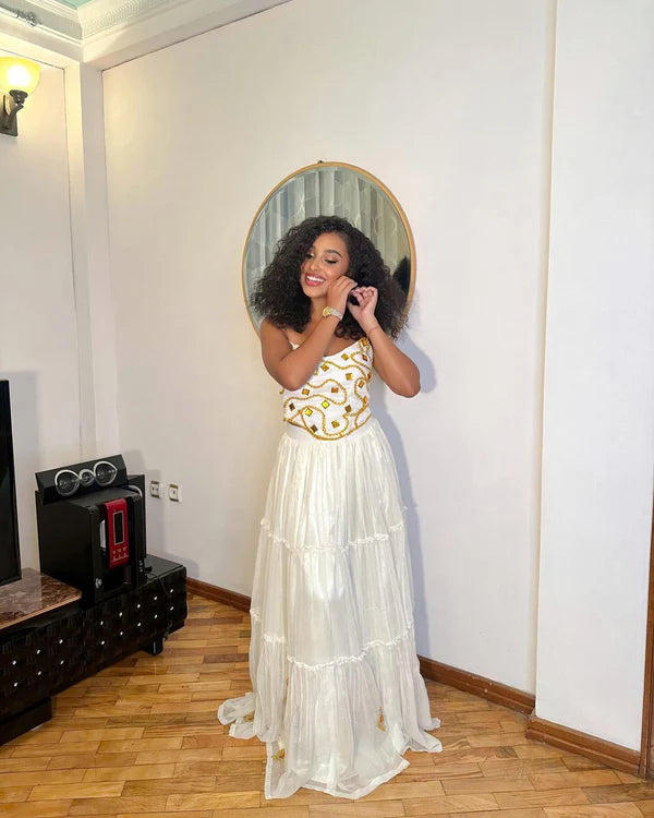 Comfortable Habesha dress features a simple design and beautiful beading.